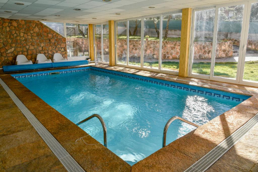 a large indoor pool in a house with windows at Casa Puente Albor PISCINA CLIMATIZADA in El Espinar