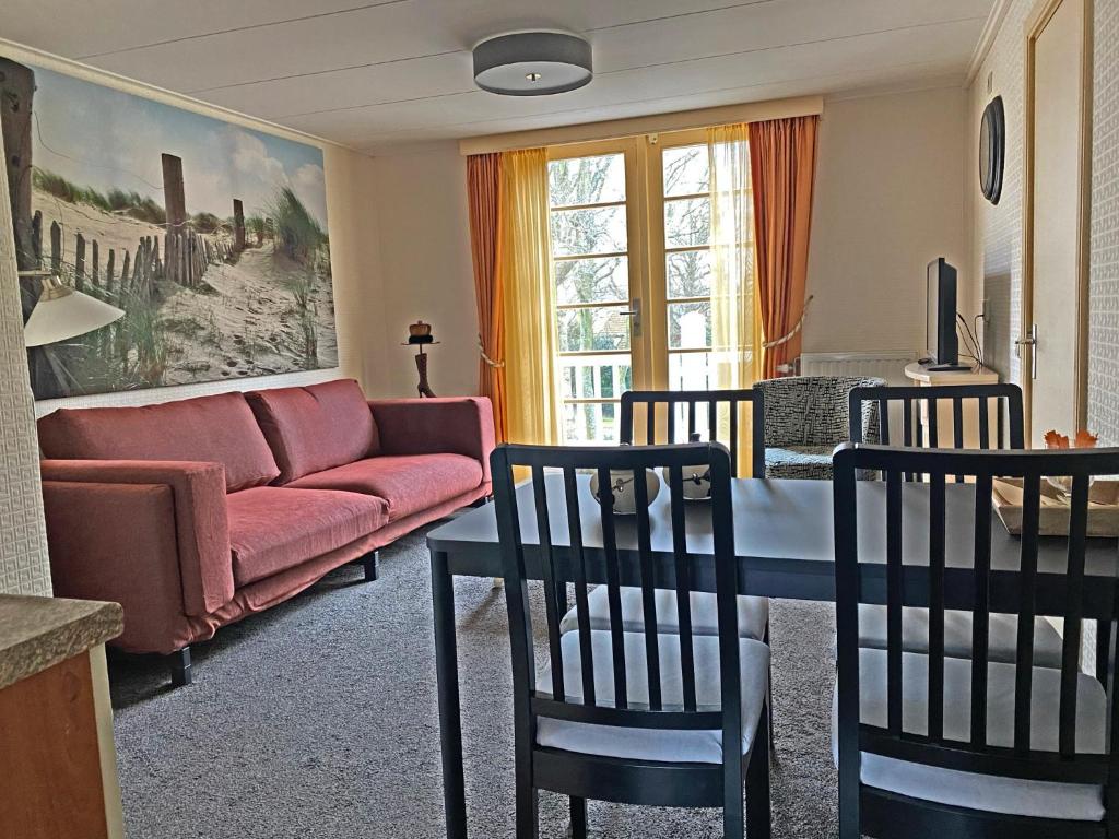 a living room with a couch and a table and chairs at Villa Prinsenhof # Tweeëntwintig in Bergen