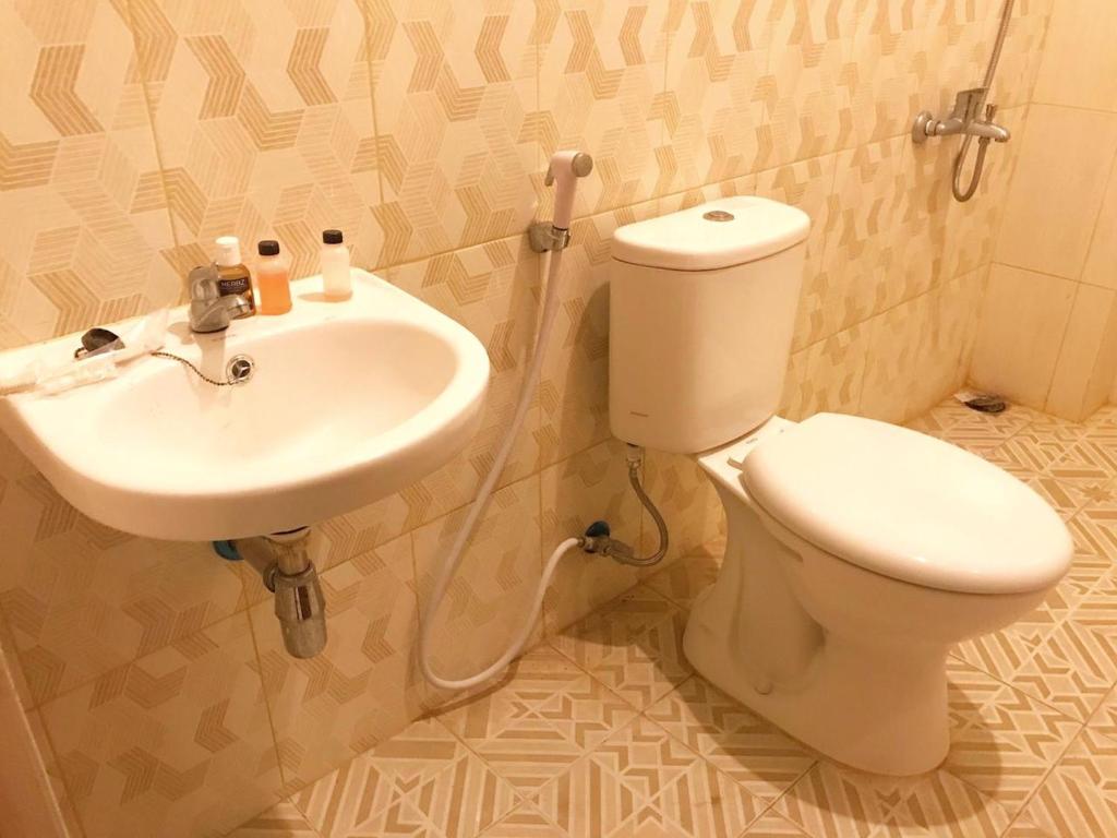 a bathroom with a toilet and a sink at Kangen Yogya Homestay Malioboro Mitra RedDoorz in Yogyakarta