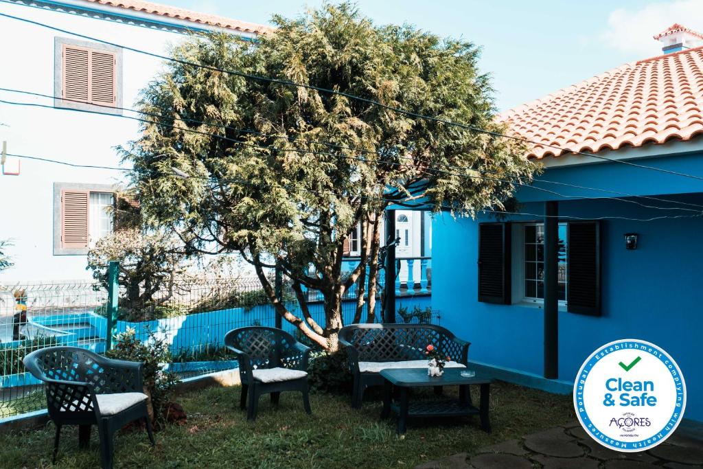 a table and chairs in front of a blue house at Cordeiro's House in Arrifes