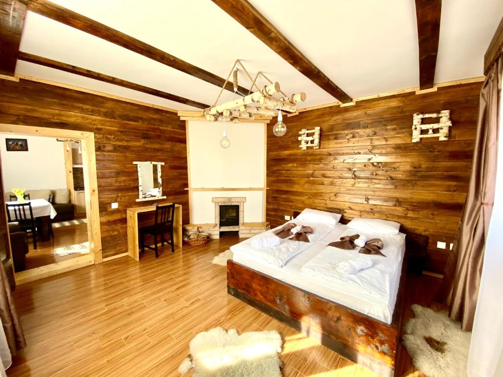 1 dormitorio con 1 cama y pared de madera en Casa Margau, en Mărgău