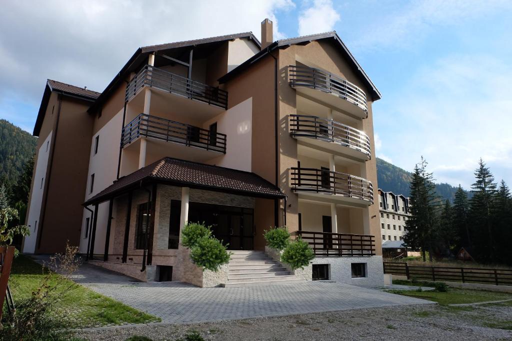 um grande edifício com escadas em frente em Poiana Ski Residence Apartment 5 em Poiana Brasov