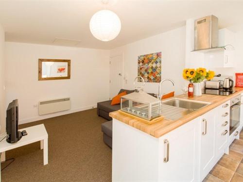 a kitchen with a sink and a living room at Beddoe Apartments Premier Lodge Eastleigh near Winchester and Southampton in Eastleigh