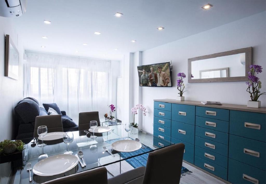 sala de estar con mesa de cristal y armario azul en MIT House Avenida America Confort XIII en Madrid, en Madrid
