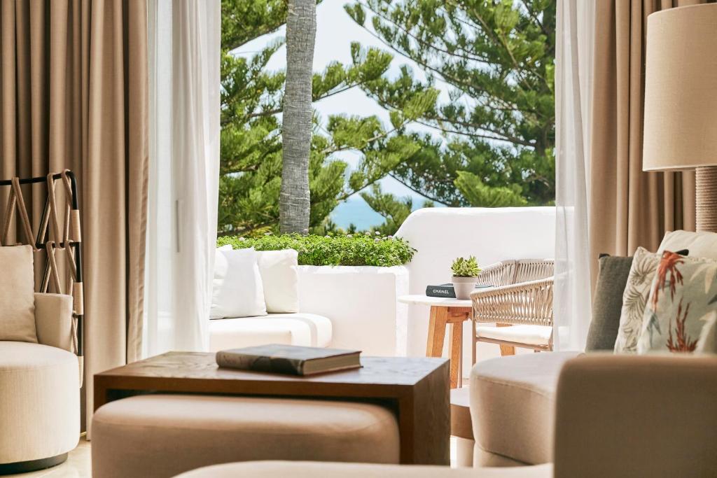 a living room with white furniture and a large window at Puente Romano Marbella in Marbella