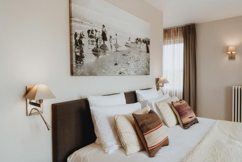 una camera con un letto con una foto sul muro di Grand Hotel Belle Vue a De Haan