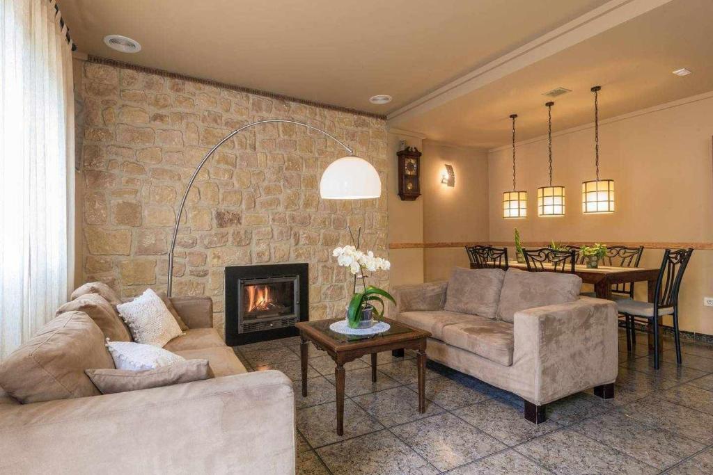 sala de estar con 2 sofás y chimenea en Casa Rural Ca Lluis en La Vall de Laguar