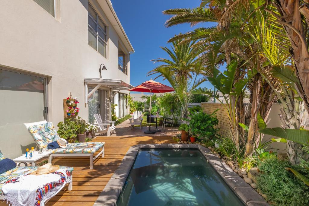 a backyard with a swimming pool and a house at Apartment Melkbos Moments in Melkbosstrand