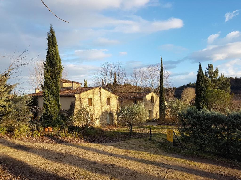 una vieja casa de piedra con árboles y un camino de tierra en Chambres d'Hôtes Aux Tournesols, en Malaucène