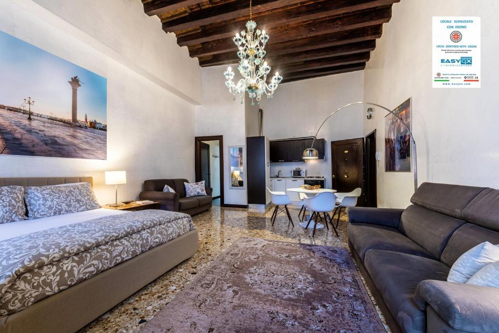 a bedroom with a bed and a couch and a table at Cà Sant'Angelo in Venice