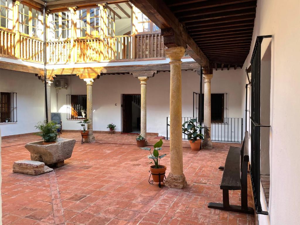 a courtyard with pillars and potted plants in a building at Apartamentos Centro del VINO Tandal in Ronda