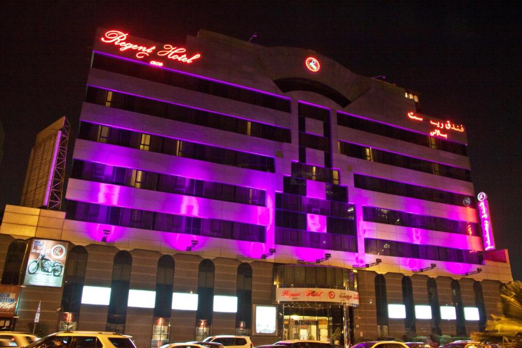un edificio con luces púrpuras en el lateral. en Regent Palace Hotel, en Dubái