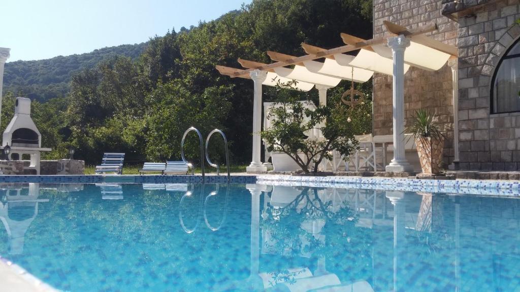 a swimming pool with a pergola next to a house at Villa D'amore Montenegro in Donji Morinj