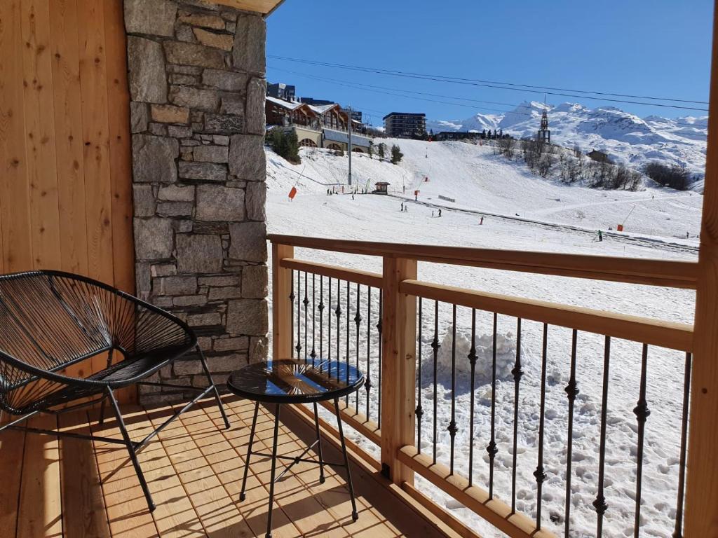 a balcony with a view of a snow covered mountain at Chalet Le Granitic in Les Menuires