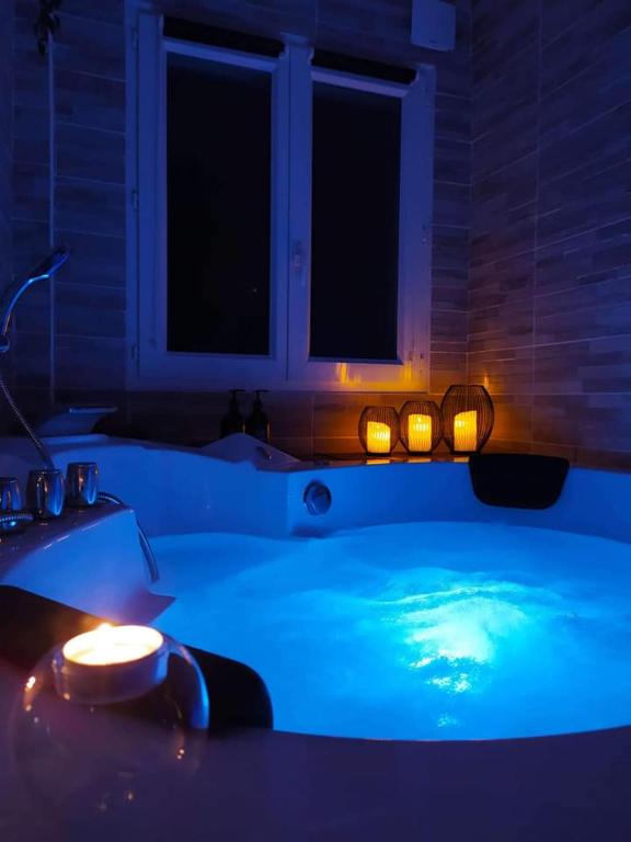 a blue bath tub with lights in a room at A l&#39;Orée des pins - Gite indépendant avec baignoire balnéo et Home Cinéma en sup - Voir info de l&#39;hôte in Cuges-les-Pins