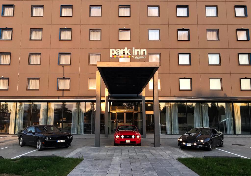 a car is parked in front of a building at Park Inn by Radisson Vilnius Airport Hotel & Business Centre in Vilnius