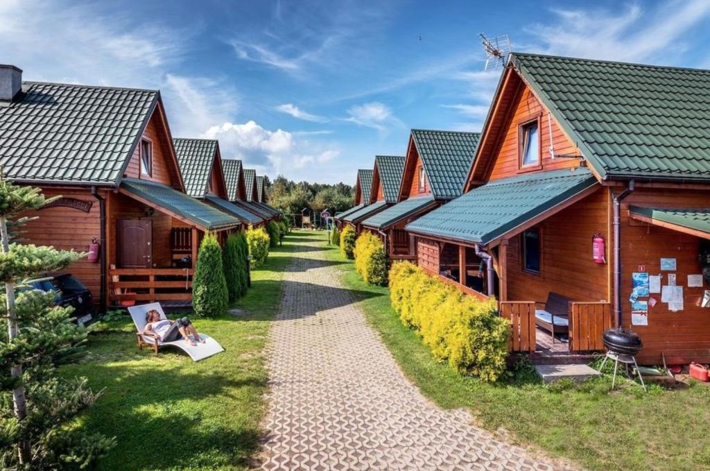une rangée de cabines en bois dans un complexe dans l'établissement Domki u Reksa, à Dębki
