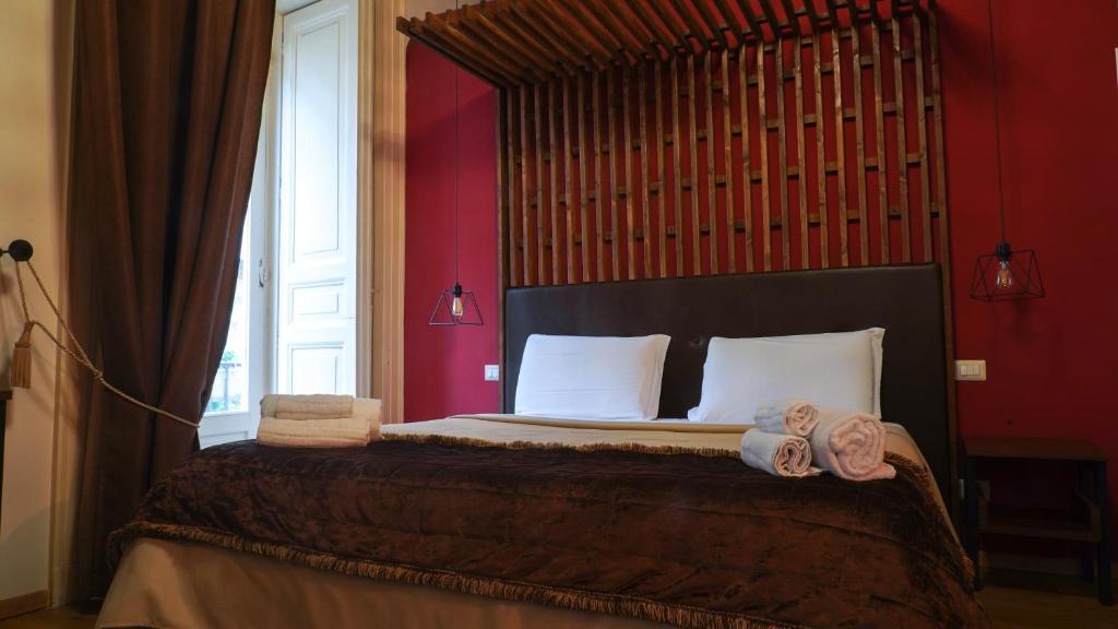 ナポリにあるDuomo Luxury Suitesのベッドルーム1室(ベッド1台、タオル2枚付)