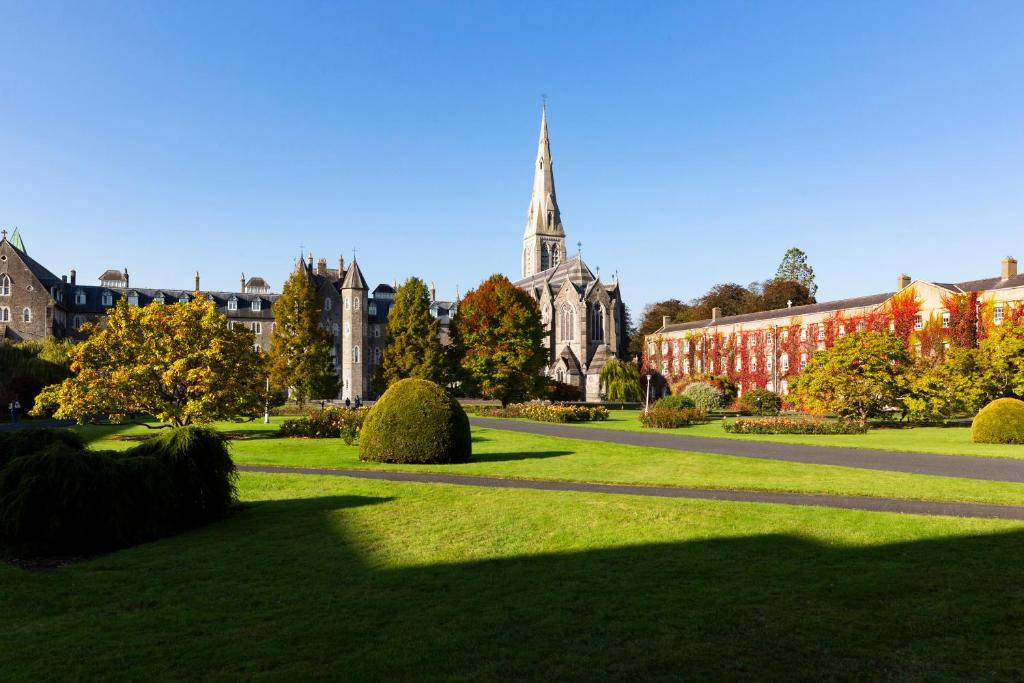 a park in front of a building with a church at Maynooth Campus Accommodation in Maynooth