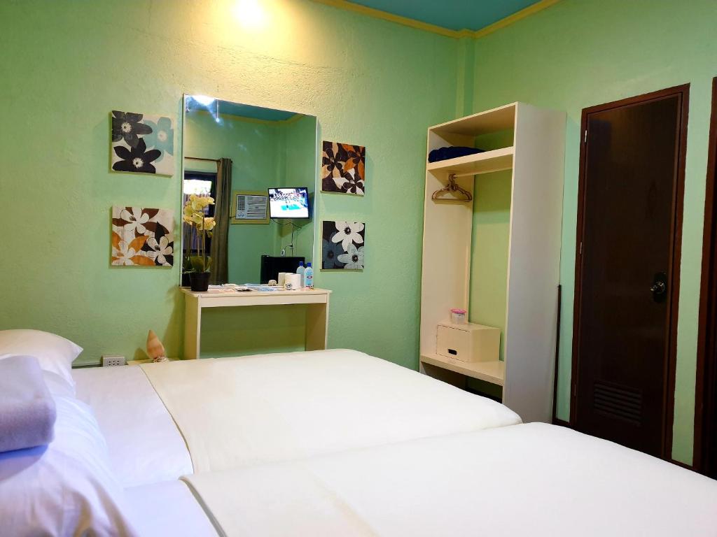 Schlafzimmer mit einem weißen Bett und einem Spiegel in der Unterkunft MJ's Residences Garden Hotel and Kids Indoor Playhouse in Moalboal