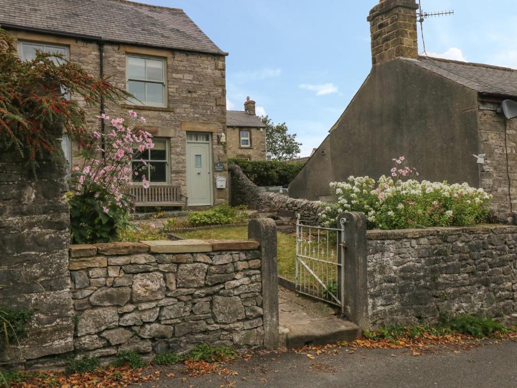 an old stone fence in front of a house at 4 Cherry Tree Cottages in Bradwell