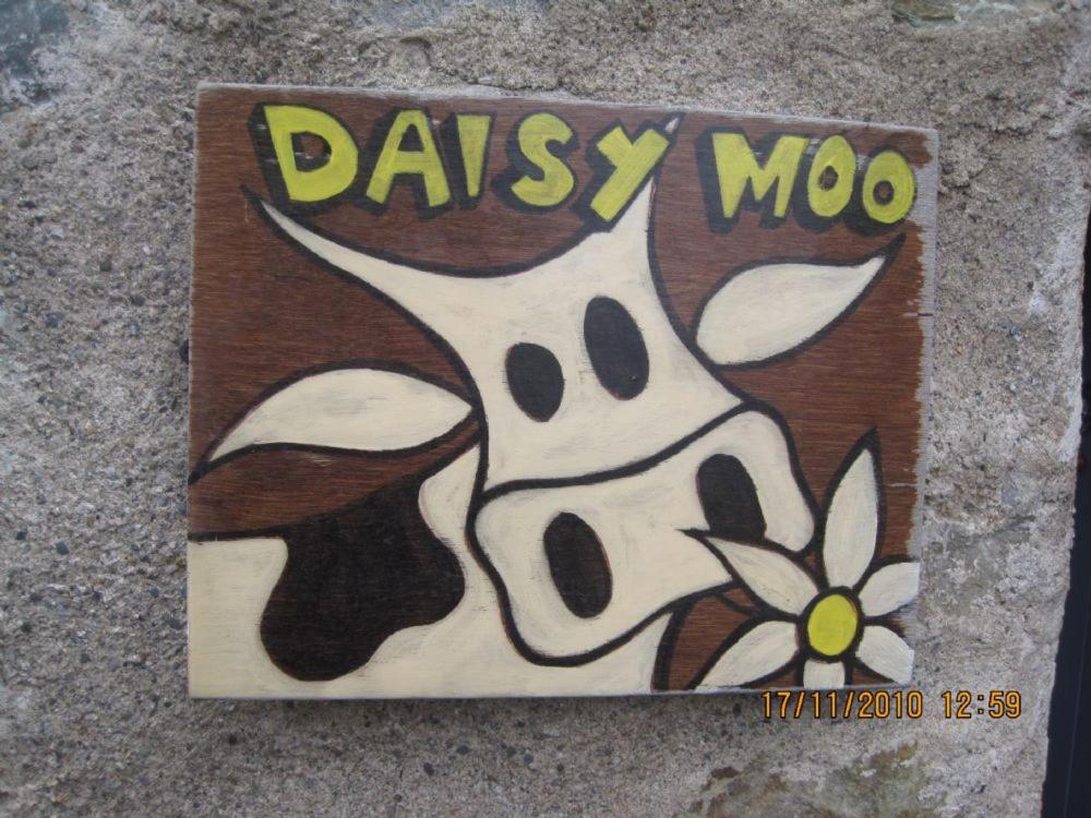 a sign with a drawing of a dog on it at Daisy Moo in Llanrhyddlad