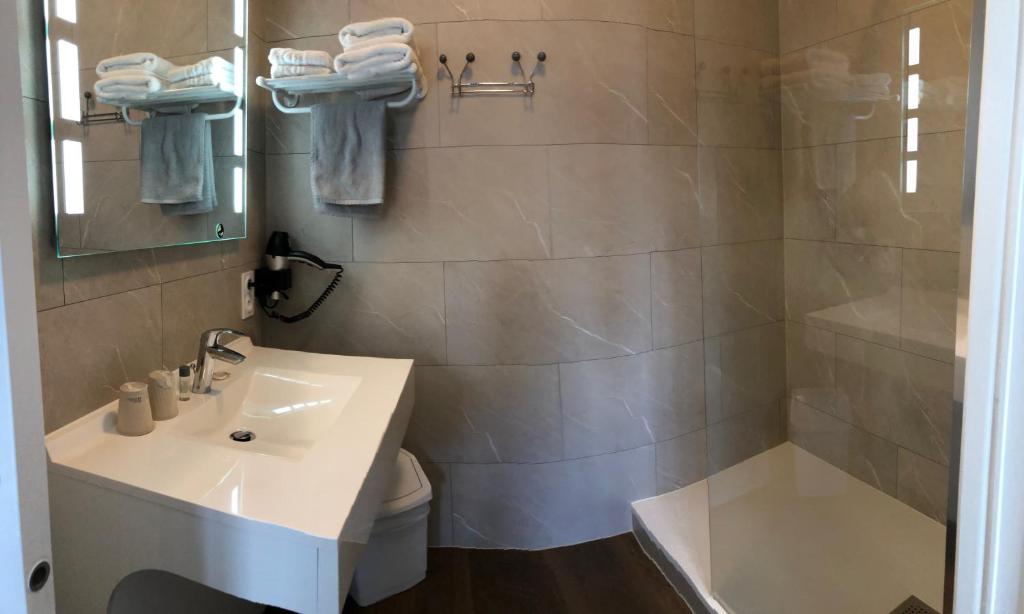 a bathroom with a sink and a toilet and a shower at Cit'Hotel Atlantis in Royan