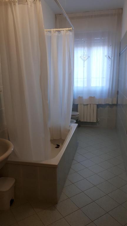 łazienka z wanną i zasłoną prysznicową w obiekcie La Conchiglia w mieście Porto SantʼElpidio