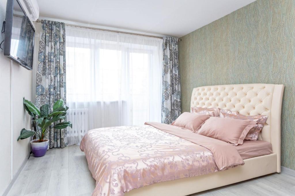 1 dormitorio con cama con sábanas rosas y ventana en StudioMinsk 4 Apartments - Minsk, en Minsk