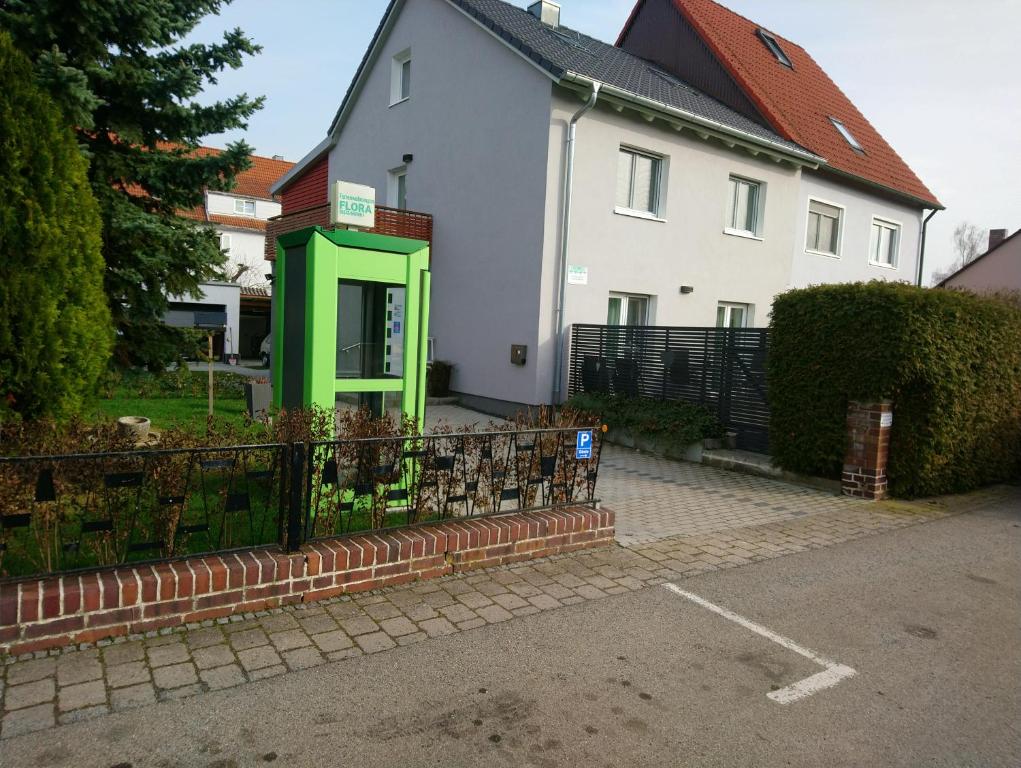 uma casa com uma cabine telefónica verde em frente em Ferienwohnungen Flora em Bad Windsheim