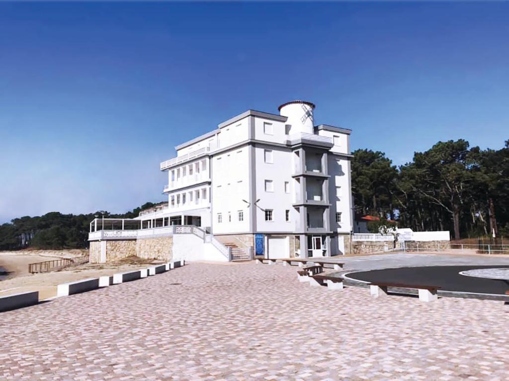 un edificio blanco sentado en la parte superior de una carretera de piedra en Hotel El Molino, en A Guarda