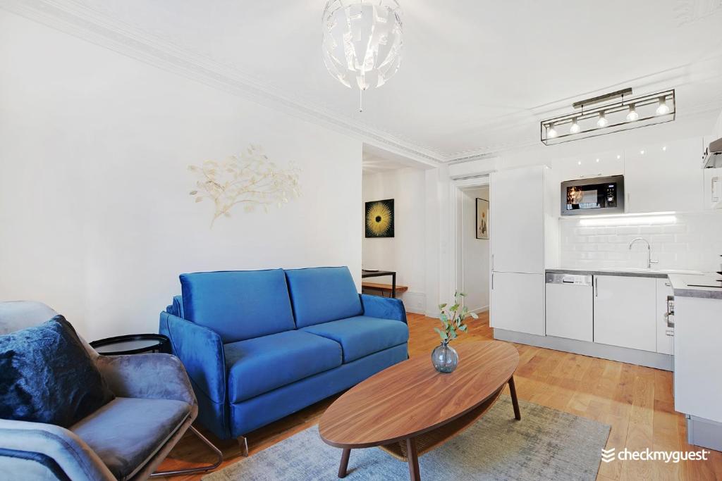 un salon avec un canapé bleu et une table dans l'établissement Splendid apartment - 2BR-6P - Place des Vosges, à Paris