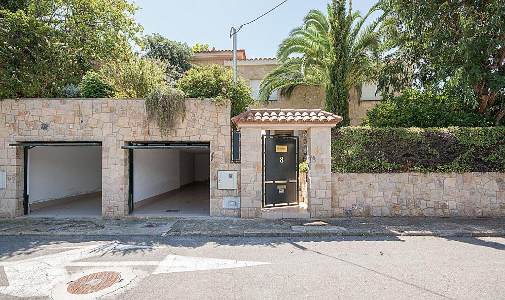 a stone building with two garage doors and a gate at Holiday House close to Port Aventura in Salou