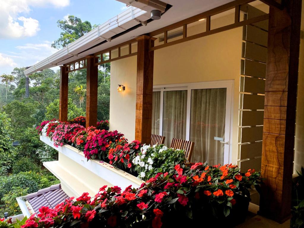 a porch with red and white flowers on it at Flower Valley Plantation Homestay in Munnar