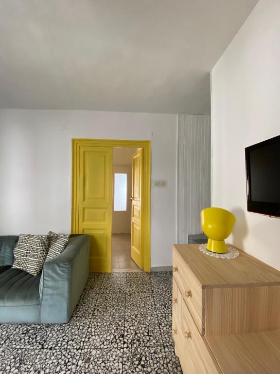 モラーノ・カーラブロにあるMaria Guesthouseのリビングルーム(ソファ付)と黄色のドア