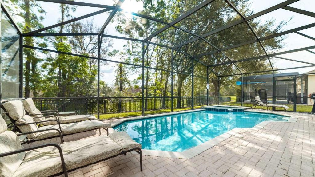 a swimming pool in a glass house with a patio at Luxury Villa with Private Pool on Windsor Hills Resort, Orlando Villa 4857 in Orlando