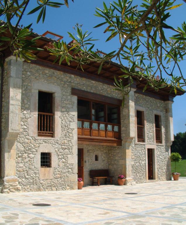 a house with a balcony on the side of it at Hotel Aldama Golf in Quintana de Llanes