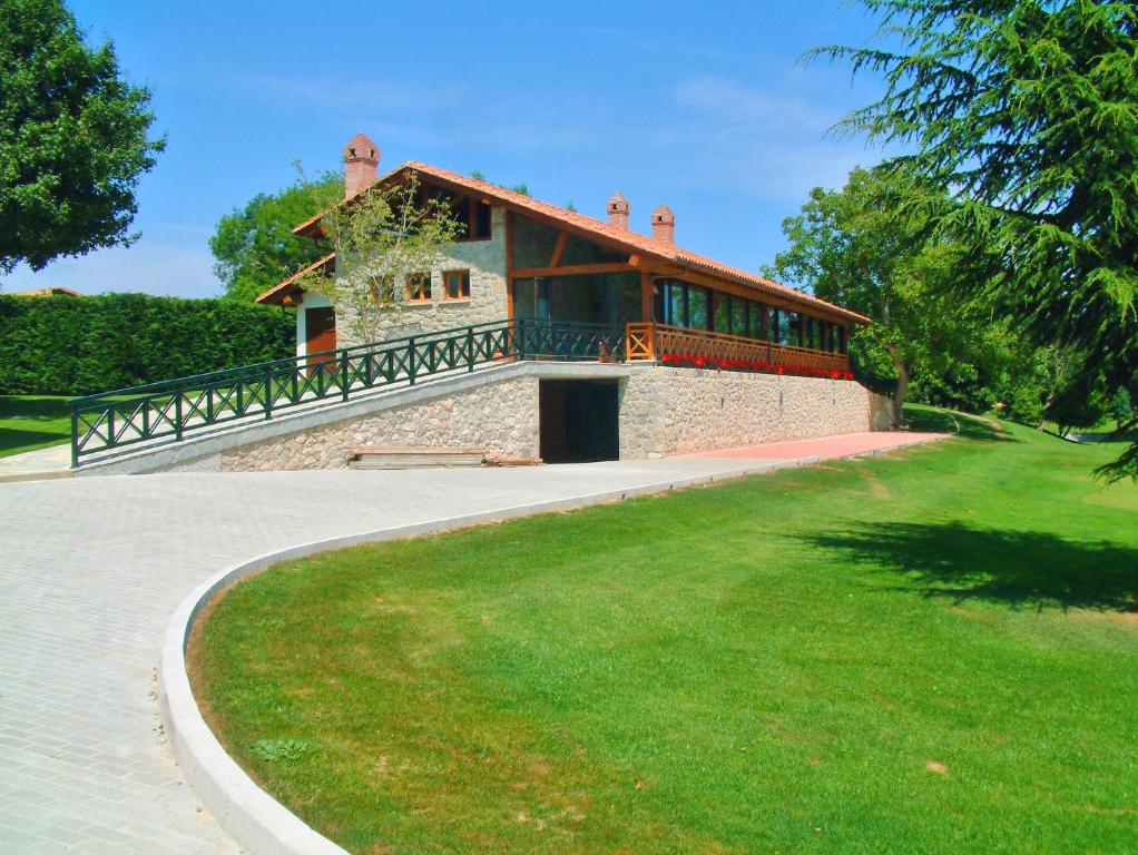 a building with a balcony on top of a lawn at Hotel Aldama Golf in Quintana de Llanes