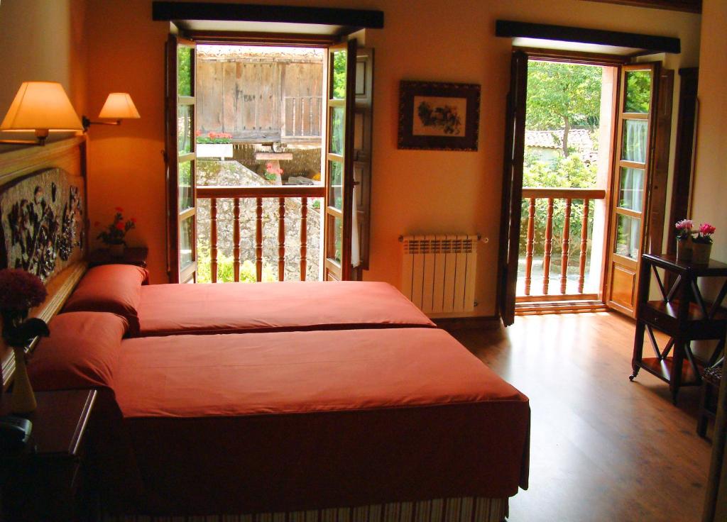 a bedroom with a bed and a balcony with sliding doors at Hotel Aldama Golf in Quintana de Llanes