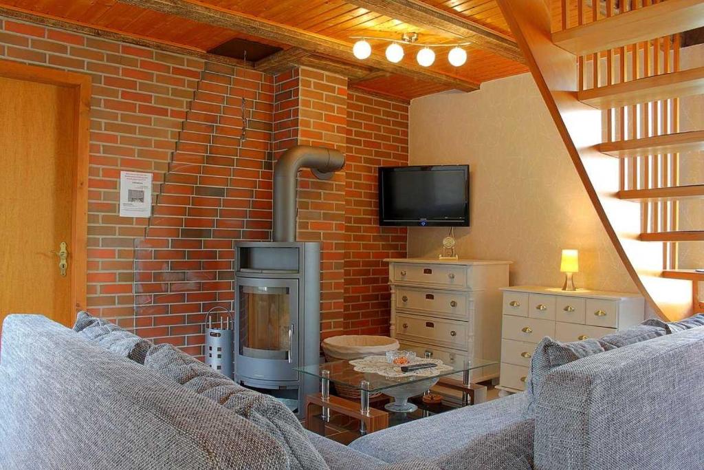 a living room with a brick wall with a fireplace at WB2 Dat luette Hus in Dorum