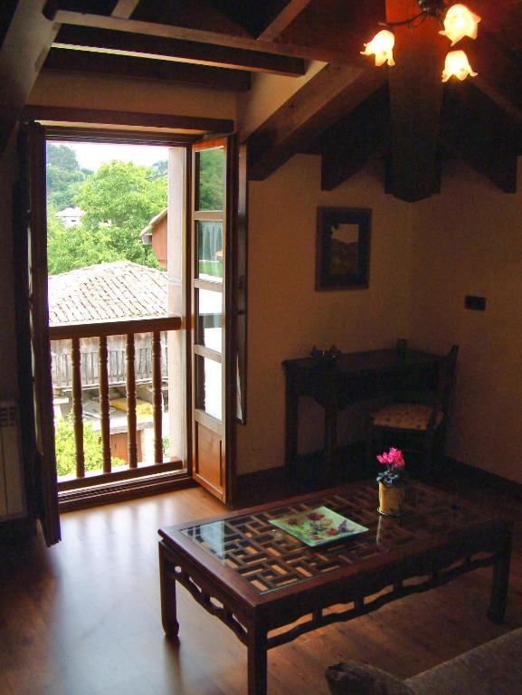a living room with a table and a sliding glass door at Hotel Aldama Golf in Quintana de Llanes