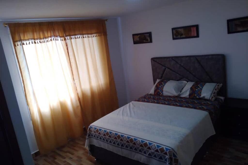 um pequeno quarto com uma cama e uma janela em Piso 3-Apartment near to Cali airport em Palmira