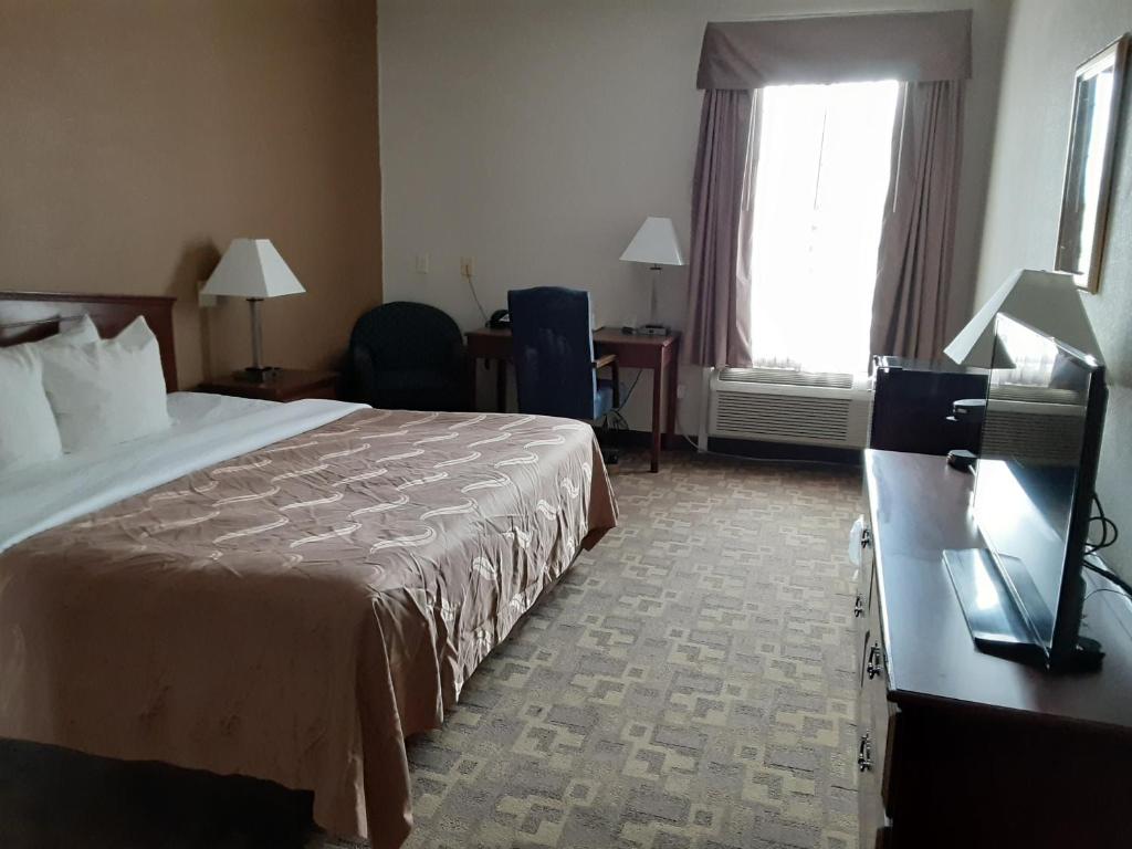a hotel room with a bed and a desk and a window at Quality Inn & Suites Schoharie near Howe Caverns in Schoharie
