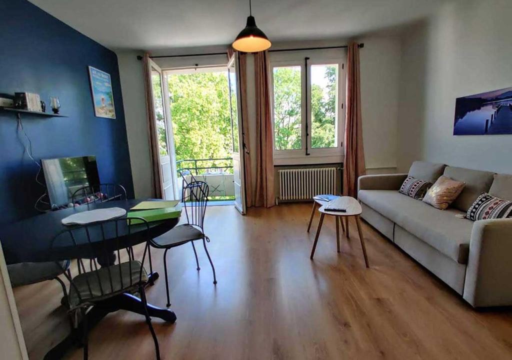 a living room with a couch and a table and chairs at Appartement spacieux centre Aix les Bains in Aix-les-Bains