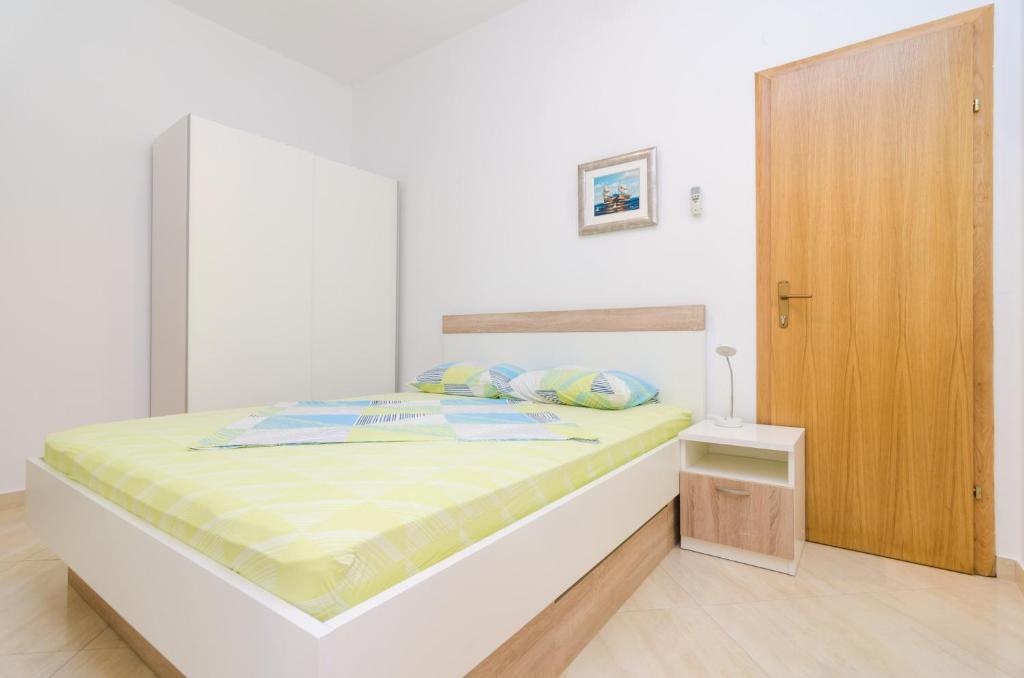 a bedroom with a bed and a wooden cabinet at Rooms &amp; Apartments Barišić in Mlini