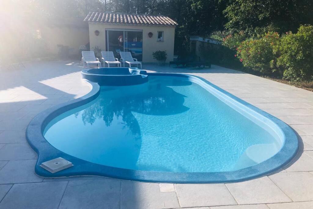 a large blue swimming pool in a yard at maisonette Cosi in Fayence