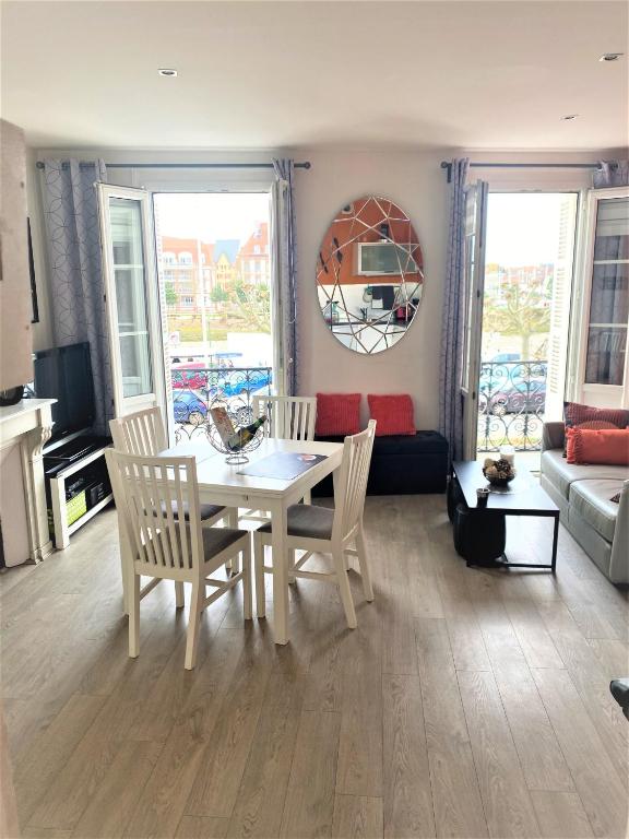 un salon avec une table et des chaises blanches dans l'établissement Le rêve Trouvillais, à Trouville-sur-Mer
