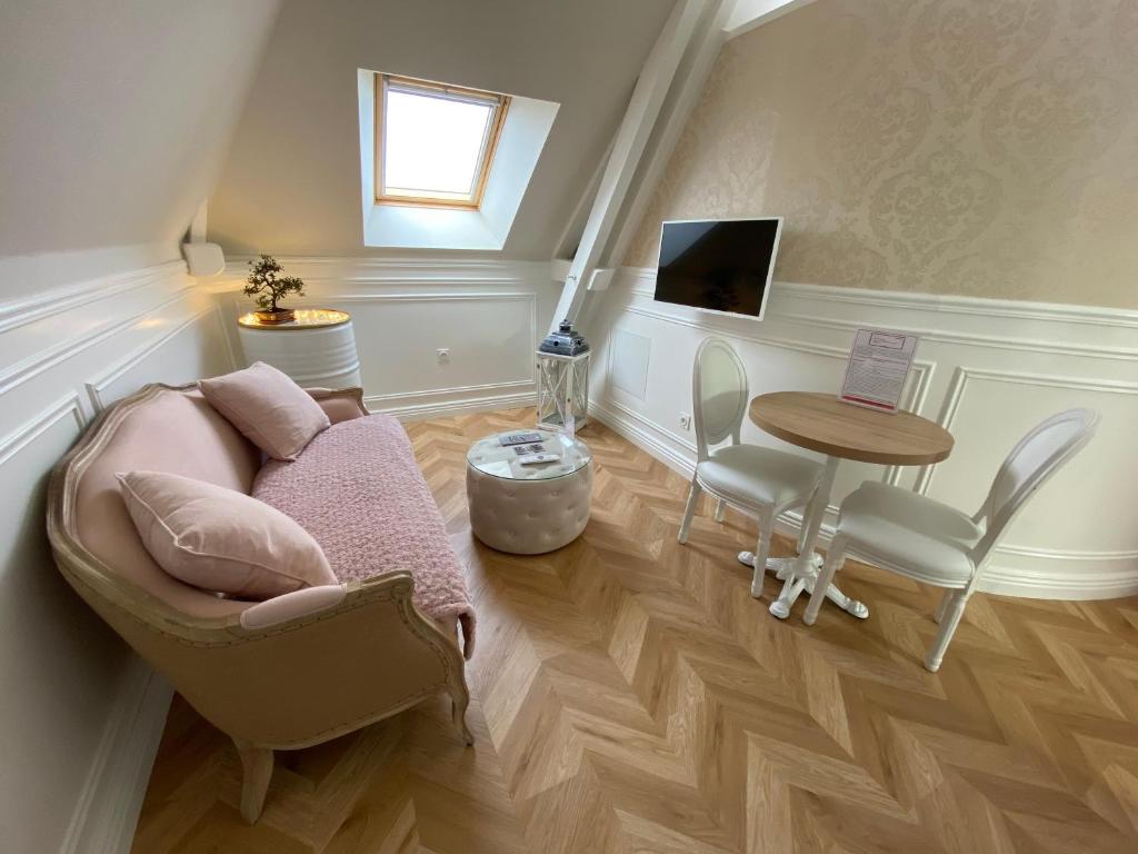 ein Wohnzimmer mit einem Sofa und einem Tisch in der Unterkunft La Demeure De Charme in Troyes