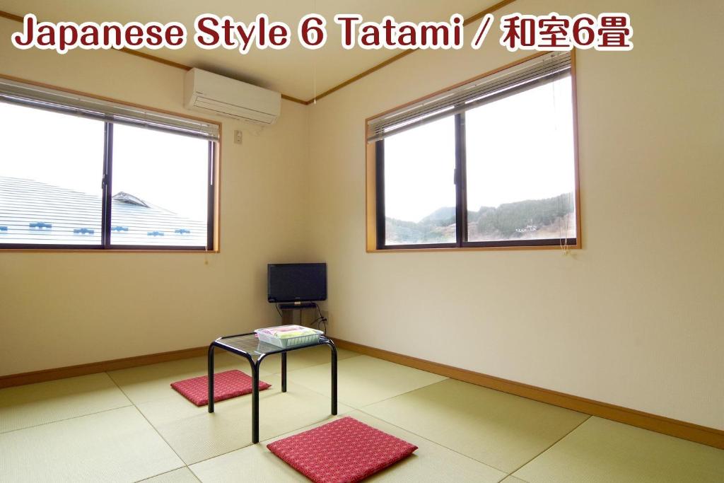 um quarto com duas janelas e uma mesa e uma televisão em NIKKO stay house ARAI - Vacation STAY 14988v em Nikko