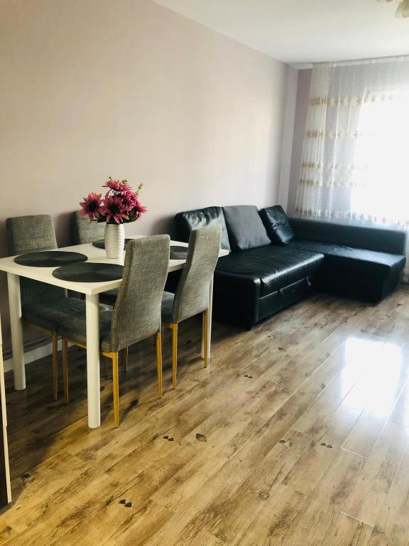 een woonkamer met een zwarte bank en een tafel bij Sighisoara apartment in Sighişoara